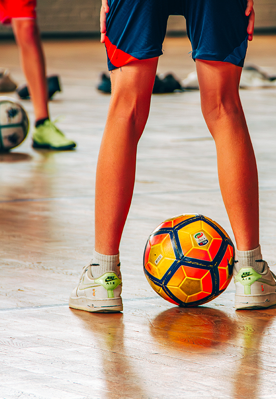 Adolescents jouant au football sur un terrain intérieur dans une salle de sport, activité sportive de l’association A.R.C.A.D.E.