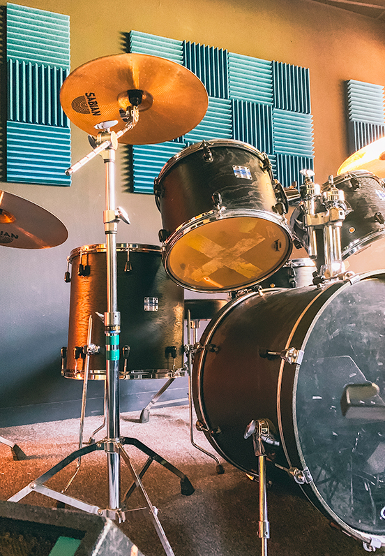 Studio de répétition et d’enregistrement de l’association A.R.C.A.D.E, vue d’un studio avec gros plan sur une batterie, équipé pour accueillir musiciens et groupes.
