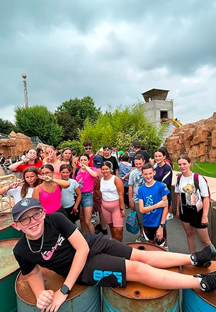 Groupe d'adolescents souriants lors d'une sortie dans un parc d'attractions avec l'A.R.C.A.D.E., illustrant le dynamisme des séjours jeunesse en Normandie.